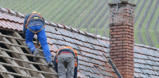 Roofer working on tiled roof installation